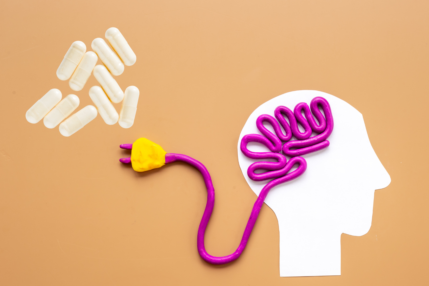 White capsules beside a stylized brain shape, representing orotate lithium and its potential role in brain support.