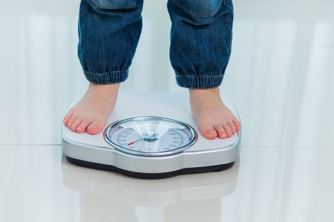 Boy measures weight on a scale