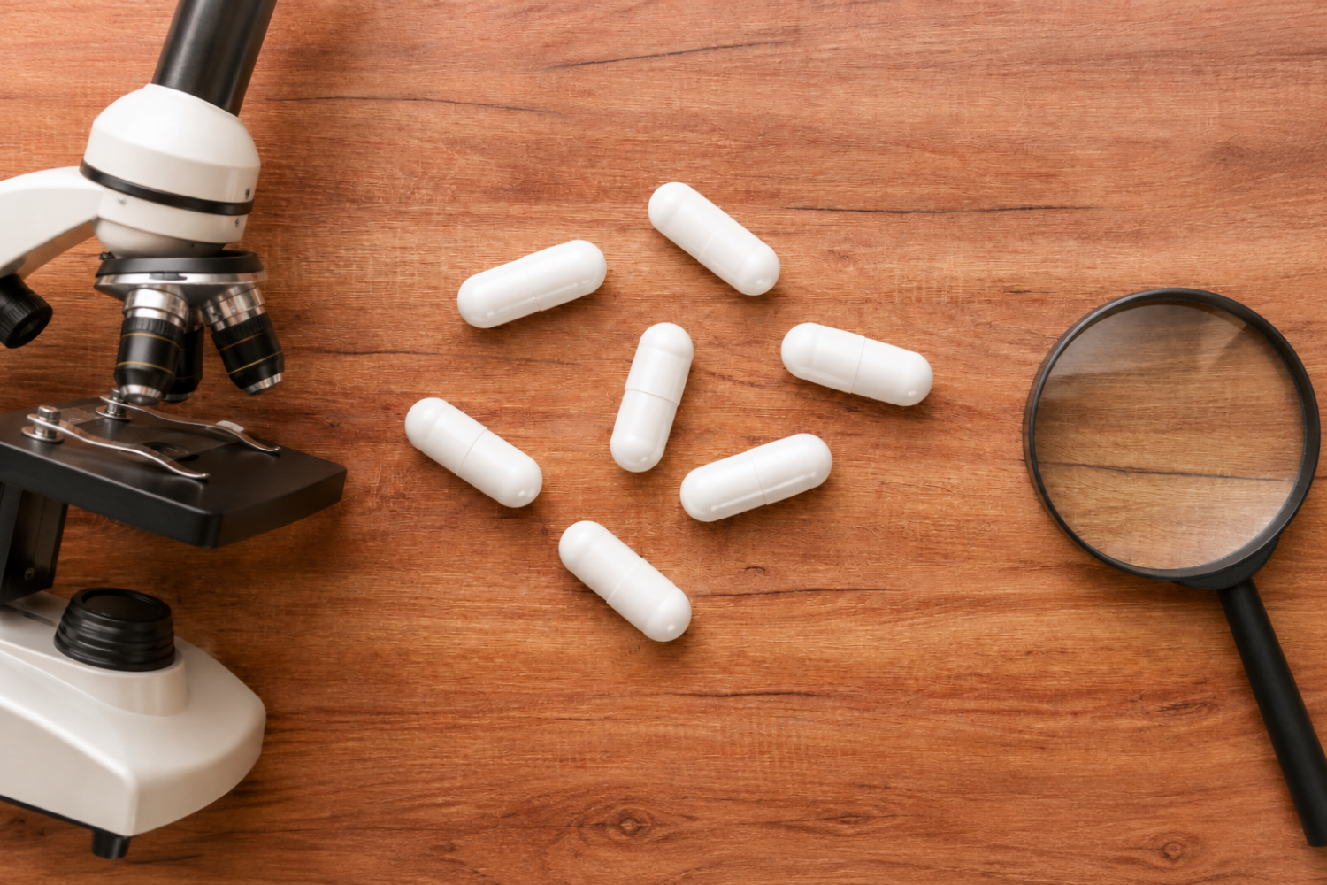 White lithium orotate supplement capsules beside a microscope and magnifying glass, representing science-based supplement evaluation.